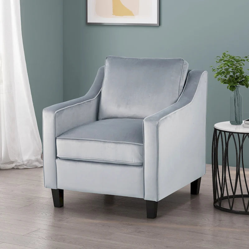 Fauteuil club contemporain en velours avec accoudoirs inclinés et pieds en bois de bouleau